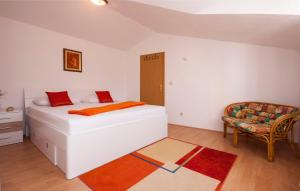ein Schlafzimmer mit einem weißen Bett und einem Stuhl in der Unterkunft Apartments Tresan in Tribunj