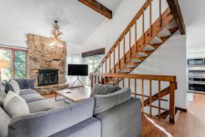 a living room with a couch and a stone fireplace at Meadow Lodge - Dog Friendly! in Frisco