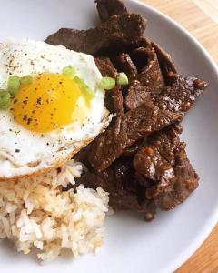 Pinoykano home في Candijay: طبق من الطعام مع بيض مقلي ورز