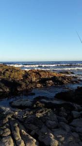 une plage rocheuse avec l'océan en arrière-plan dans l'établissement Punta Negra-disfrutable todo el año, à Maldonado