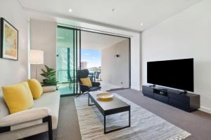 a living room with a couch and a tv at Quattro on Astor in Brisbane