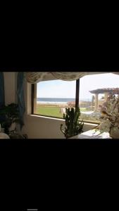 a window in a room with a view of the ocean at Oceana Rosarito Condo Beach frontPrivately Owned downtown best views in Rosarito