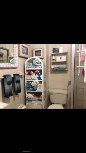 a bathroom with a toilet and a rack of towels at Oceana Rosarito Condo Beach frontPrivately Owned downtown best views in Rosarito
