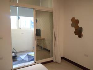 um quarto com uma porta de vidro deslizante num quarto em 910 Hostel (Chengdong) em Yuli
