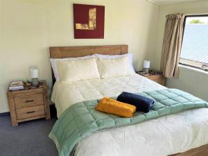 a bedroom with a bed with two pillows on it at Charm on Chippendale B&B in Palmerston North