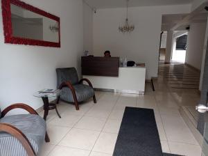 sala de estar con sillas y espejo en la pared en Hab Pequeña baño compartido La Paz 4, en Lima