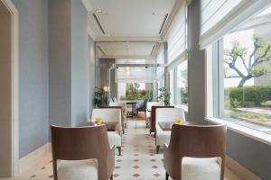 a waiting room with chairs and a table and windows at Grand Nikko Tokyo Daiba in Tokyo