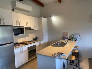 a kitchen with white cabinets and a counter top at ELM Accommodation - Merrijig in Merrijig