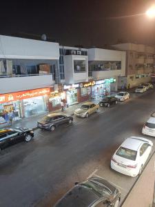 um grupo de carros estacionados numa rua da cidade à noite em OMAR Vacation em Dubai