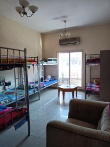 a living room with bunk beds and a couch at Suzy Hostel for boys in Dubai