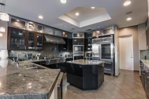 eine große Küche mit Küchengeräten aus Edelstahl und Granitarbeitsflächen in der Unterkunft Exclusive, Upscale Palm Springs Estate with 5-Star Amenities in Palm Springs