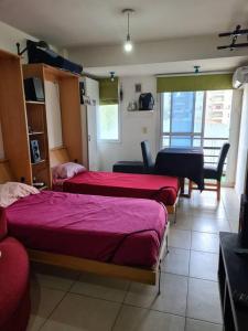 a bedroom with two beds and a dining room with a table at Sweet home a 7 min del Colegio Militar de Palomar in Caseros