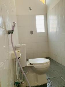 a bathroom with a toilet with a hose at Rumah DOLE in Gili Islands