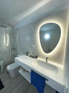 La salle de bains blanche est pourvue d'un lavabo et d'un miroir. dans l'établissement Vivienda vacacional Agripina, à Echedo