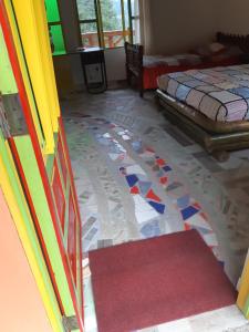 een kamer met een kleurrijke tegelvloer en 2 bedden bij Hospedaje Rural El Rancho de Amelia y Juancho in Silvania