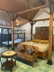 ein Schlafzimmer mit einem großen Bett und einem Tisch in der Unterkunft Pamularsih Homestay in Yogyakarta