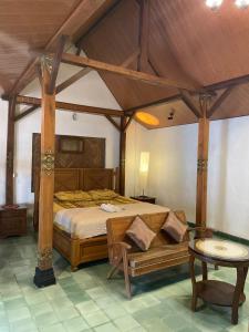 a bedroom with a large bed with a wooden canopy at Pamularsih Homestay in Yogyakarta