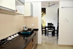 une cuisine avec des murs blancs et un comptoir noir dans l'établissement 2BHK Lake View Apartment, à Lavasa