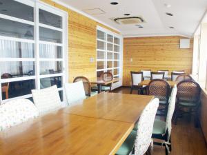 een eetkamer met een houten tafel en stoelen bij olive no sato vingh four eyes shodoshima / Vacation STAY 79065 in Kusakabe