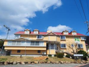 een groot geel gebouw met een rood dak bij olive no sato vingh four eyes shodoshima / Vacation STAY 79065 in Kusakabe