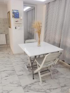 una mesa blanca y sillas en una habitación con suelo de mármol en Écrin, en Sousse