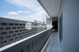 un balcon d'un bâtiment avec le panneau rouge du partenaire. dans l'établissement Athena House Syariah Near The Park Mall Solo Baru Mitra RedDoorz, à Sukoharjo