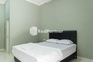 a bedroom with a bed with a red partner sign on the wall at Athena House Syariah Near The Park Mall Solo Baru Mitra RedDoorz in Sukoharjo