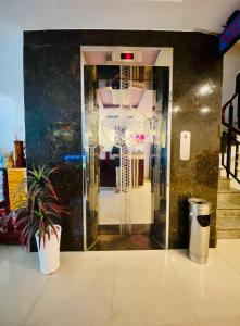 um quarto com uma porta de vidro com um vaso de plantas em Hotel Phương Nam em Ho Chi Minh