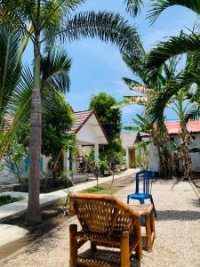 a park with two benches and palm trees at Rumah DOLE in Gili Islands