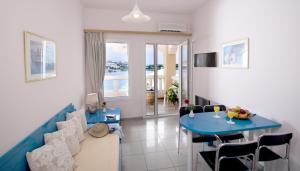 ein Wohnzimmer mit einem blauen Tisch und Stühlen in der Unterkunft Scala Hotel-Apartments in Agia Pelagia