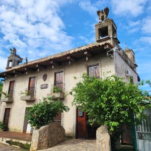 uma casa velha com um cão no telhado em Hostal casa de las gargolas em Amapala