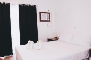 a bedroom with a bed with two penguins on it at Meili Beach Resort in Alcoy