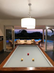 a pool table in a living room with a ceiling at Villa spa Grand Anse in Petite Île