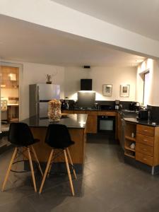 a large kitchen with two bar stools and a counter at Villa spa Grand Anse in Petite Île