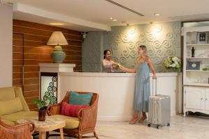 a woman is standing at a bar with a suitcase at La Petite Salil Sukhumvit 8 in Bangkok