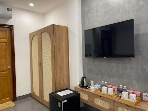 een kamer met een flatscreen-tv aan de muur bij Mai Hotel in Vung Tau