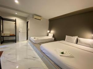 a hotel room with two beds and a bathroom at The dream garden in Ao Nang Beach