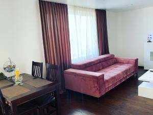 a living room with a red couch and a table at Very welcome apartment in Panevėžys
