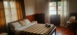 - une petite chambre avec un lit et une couverture en damier dans l'établissement L'anis Etoilé, à Antsirabe