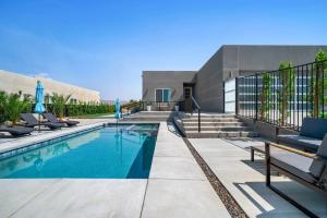 uma piscina com cadeiras ao lado de um edifício em Modern Desert Oasis – Pool, Spa and Mountain Views em Desert Hot Springs