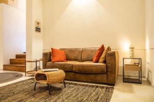 a living room with a brown couch with orange pillows at ELLEMENTS - Luxury Rooms in Brindisi
