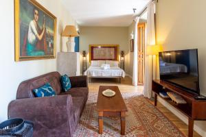 a living room with a couch and a bed at Hotel Albaicín - Auto Check-in in Coín