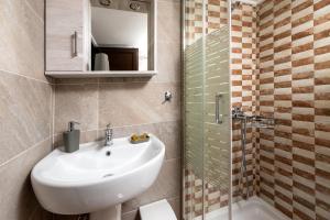 a bathroom with a sink and a mirror and a shower at Kouvlaki Effie's Place in Afissos in Afissos