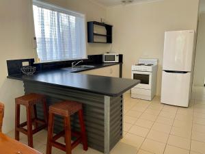 a kitchen with a black counter and a white refrigerator at Peaches in Kingscote