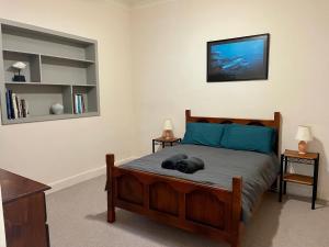 a bedroom with a bed and two night stands at Peaches in Kingscote