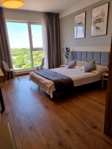 um quarto com uma cama grande e uma janela grande em Warsaw Apartments - Luxury Top-view Aparthotel em Varsóvia