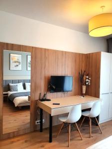 um quarto com uma secretária com 2 cadeiras e uma cama em Warsaw Apartments - Luxury Top-view Aparthotel em Varsóvia