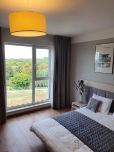 1 dormitorio con cama y ventana grande en Warsaw Apartments - Luxury Top-view Aparthotel, en Varsovia