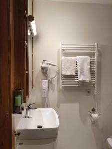 uma casa de banho com lavatório, espelho e toalhas em Warsaw Apartments - Luxury Top-view Aparthotel em Varsóvia