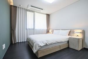 una camera d'albergo con un grande letto e una finestra di Jeju Hana Resort a Seogwipo